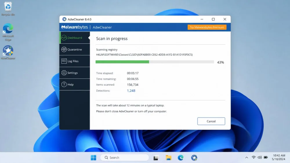 AdwCleaner mid-scan on Windows 11 with a progress bar and a running count of detected items, illustrating the roughly 12-minute full scan on a typical laptop.