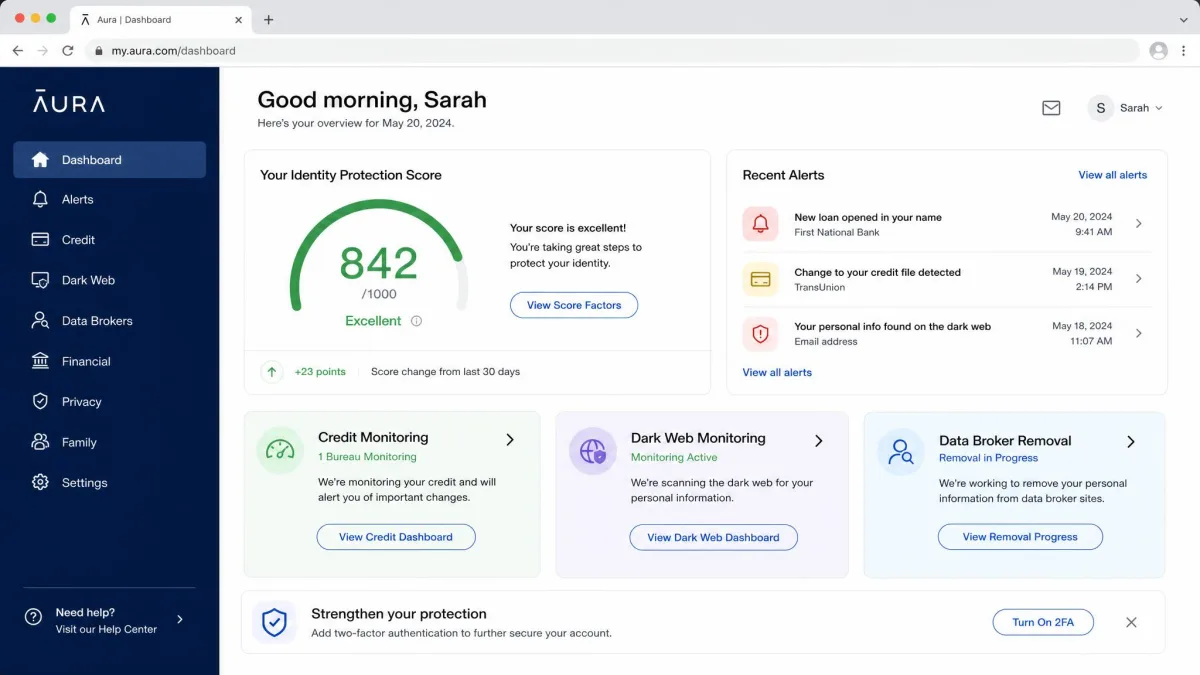 Aura's web dashboard on a desktop browser showing the identity protection score, recent alerts panel and tiles for credit monitoring, dark web monitoring and data broker removal.