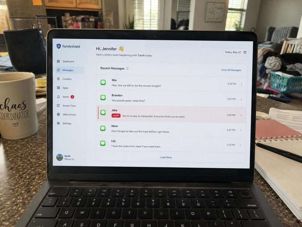 A parent monitoring dashboard on a laptop showing a feed of a child's recent text messages with one flagged as an alert.
