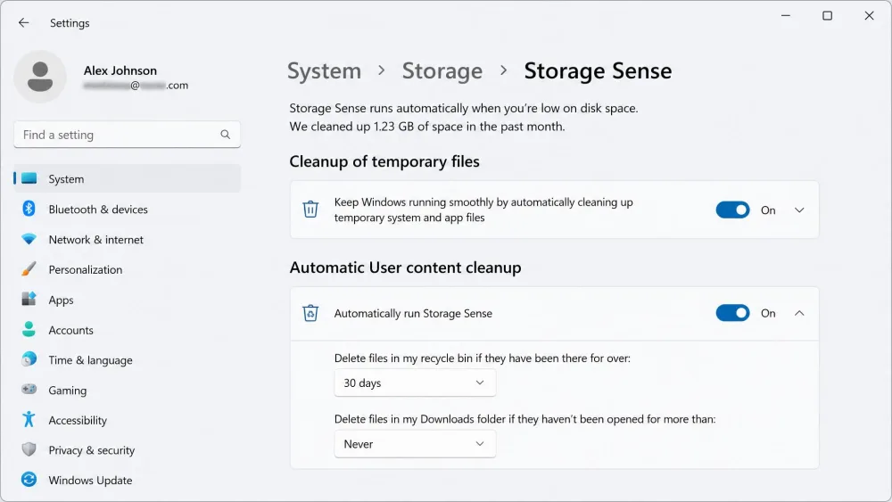 The Windows 11 Storage Sense settings page showing toggles for automatic cleanup of temporary files and scheduled emptying of the Recycle Bin.  Blur the e-mail address.