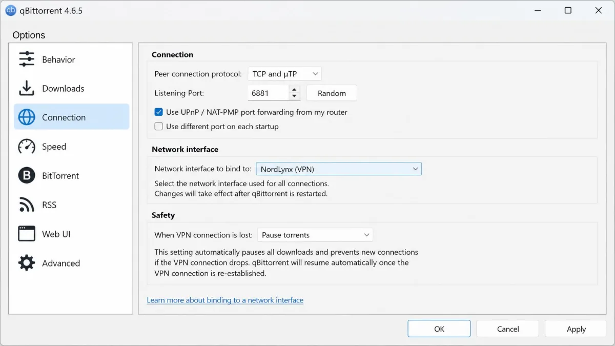 A qBittorrent settings window with the network-interface binding dropdown set to the VPN adapter, showing the safety setting that stops downloads when the VPN disconnects.