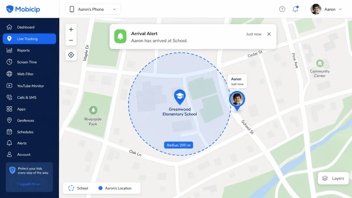 A map view in Mobicip with a circular geofence drawn around a school and a child marker just outside the boundary, with an arrival alert banner above it.