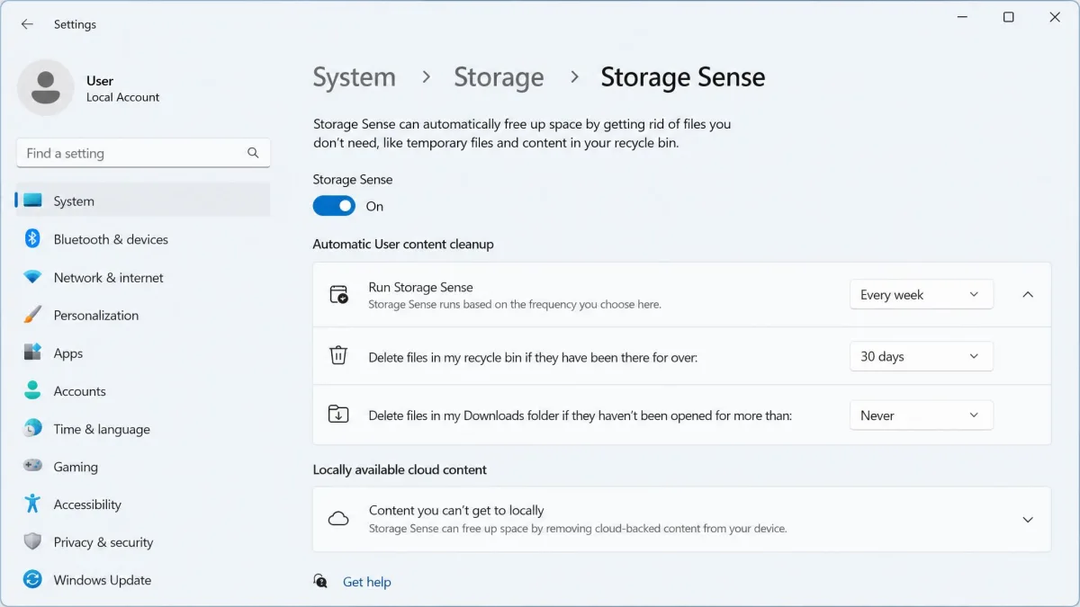 Windows 11 Storage Sense settings page with the automatic cleanup toggle on, the cleanup schedule dropdown set to Every week, and the Downloads deletion dropdown set to Never.