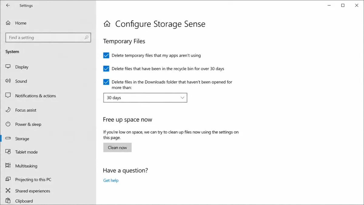 Windows 10 Configure Storage Sense page with the temporary files checkboxes, the Downloads interval dropdown and the Clean now button.