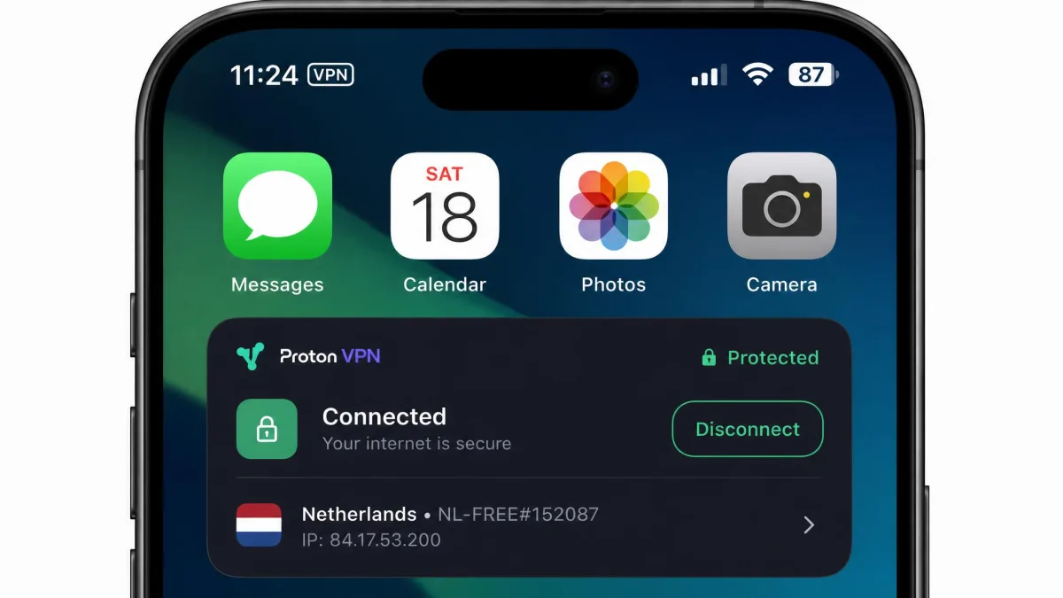 An iPhone home screen close-up showing the small VPN badge in the status bar at the top of the screen while a provider app reports a connected tunnel.