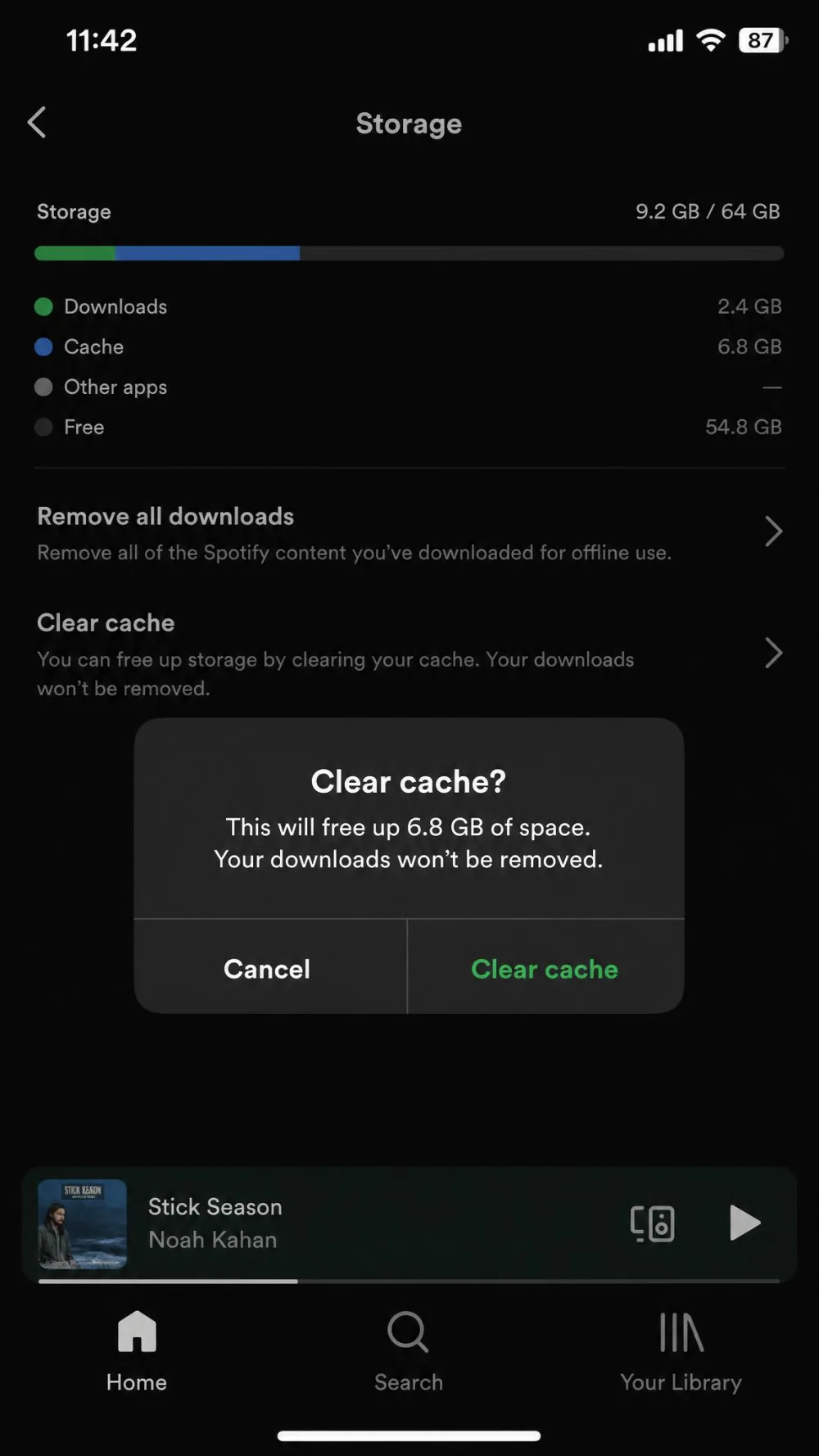 The Spotify iPhone app showing the Clear cache option under Storage with the confirmation prompt open.