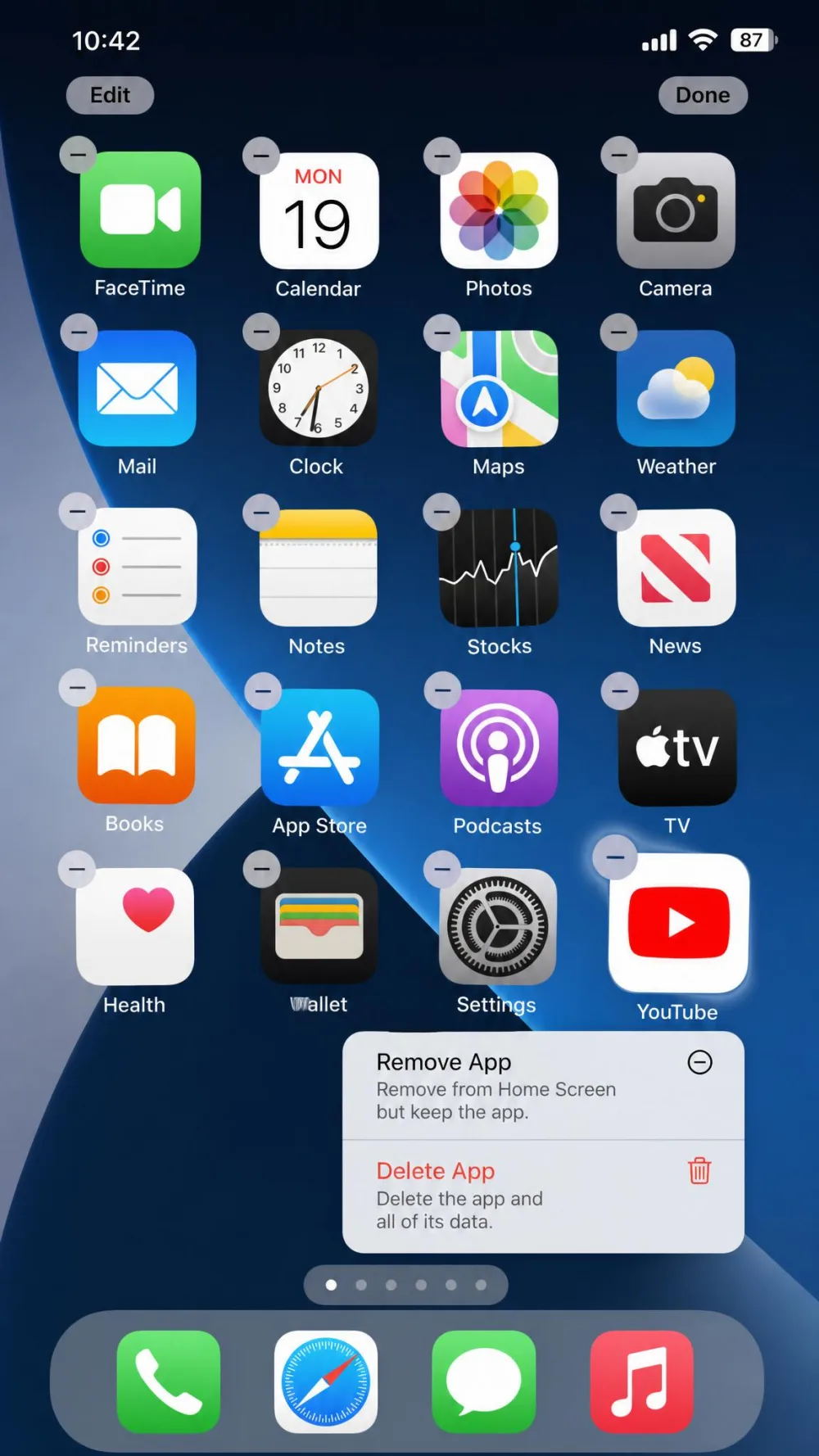 An iPhone home screen with the YouTube icon jiggling and the pop-up menu showing Remove App and Delete App, the route used to clear the cache on iOS.
