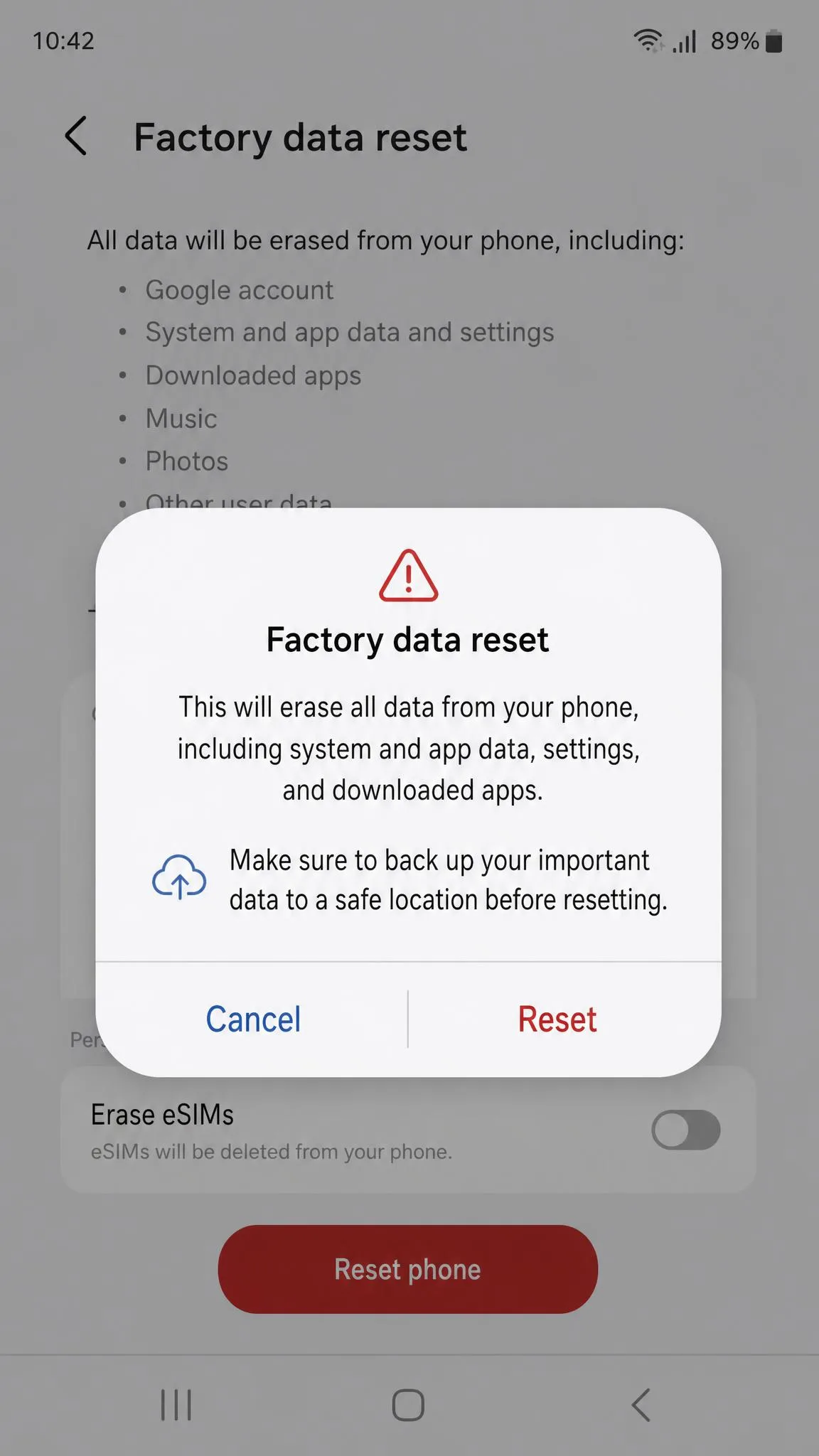 A phone settings screen showing the factory-reset confirmation dialog with a warning that all data will be erased and a back-up reminder.
