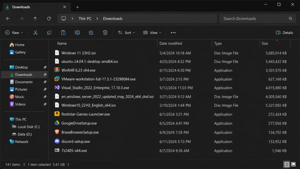 A File Explorer window open on the Downloads folder in Details view, sorted by the Size column with several large installer and ISO files listed at the top.