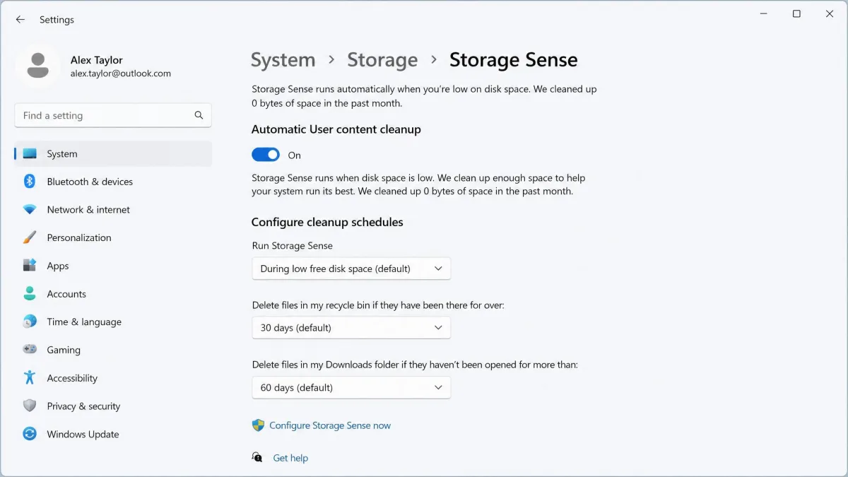 The Windows 11 Storage Sense settings page showing the automatic cleanup toggle switched on, with drop-down menus for cleanup frequency, Recycle Bin retention and Downloads folder retention.