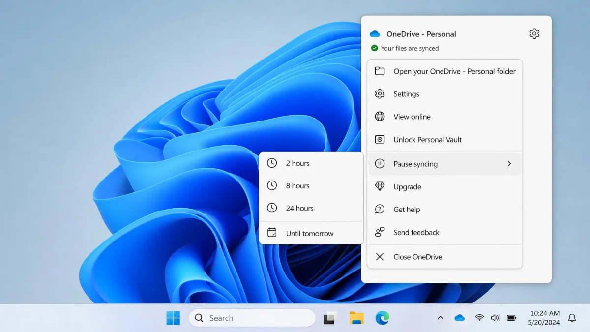 The OneDrive tray menu open on the Windows desktop with Pause syncing expanded and the 2, 8 and 24 hour options showing.