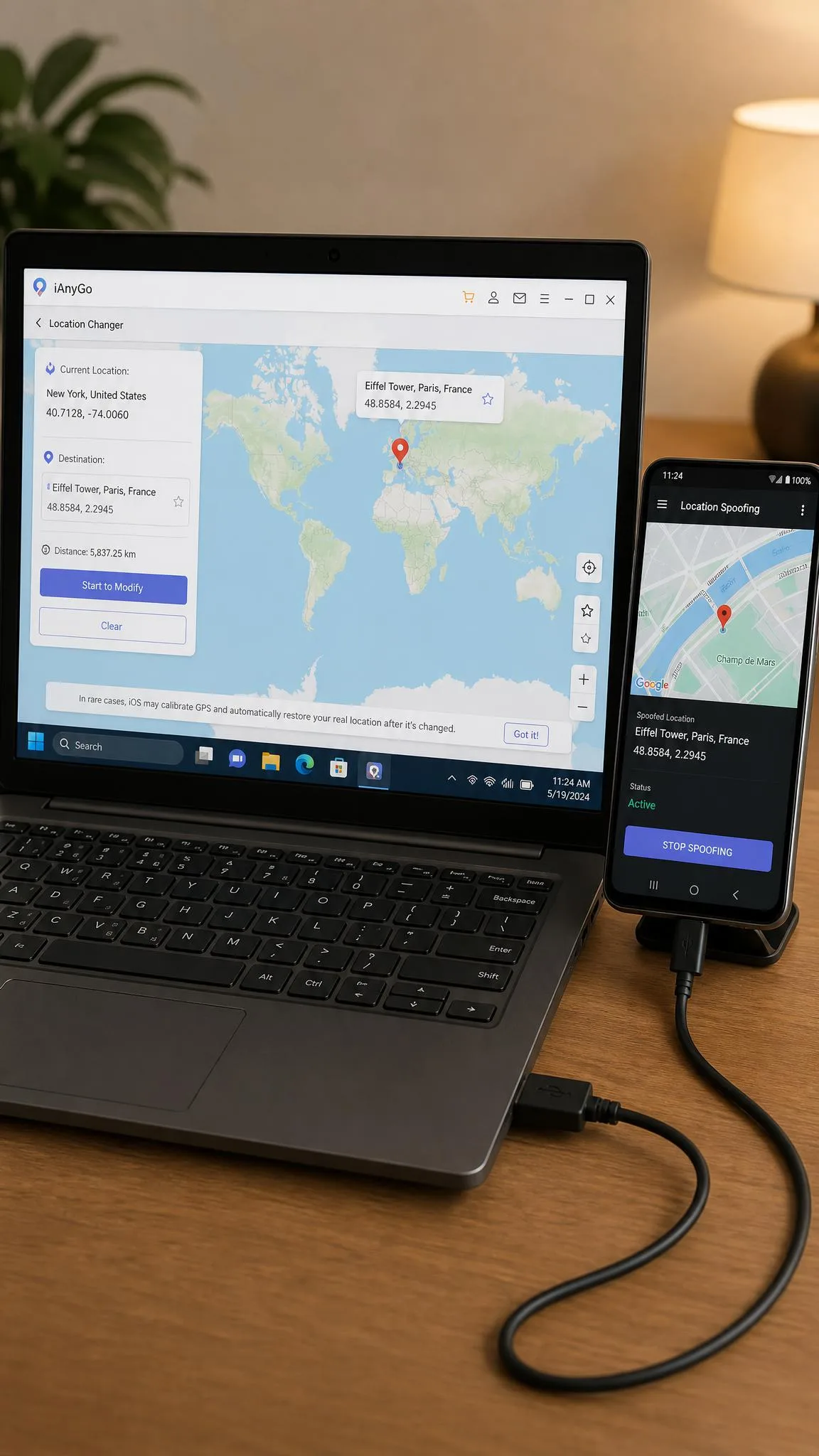 Windows laptop running a desktop location changer with a world map and a target pin, an Android phone connected by USB cable beside it showing the matching spoofed position.