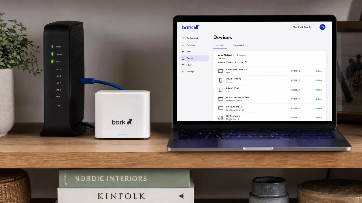 The Bark Home hardware unit plugged into a home router on a shelf, with a laptop nearby showing the network device list in the Bark parent app.