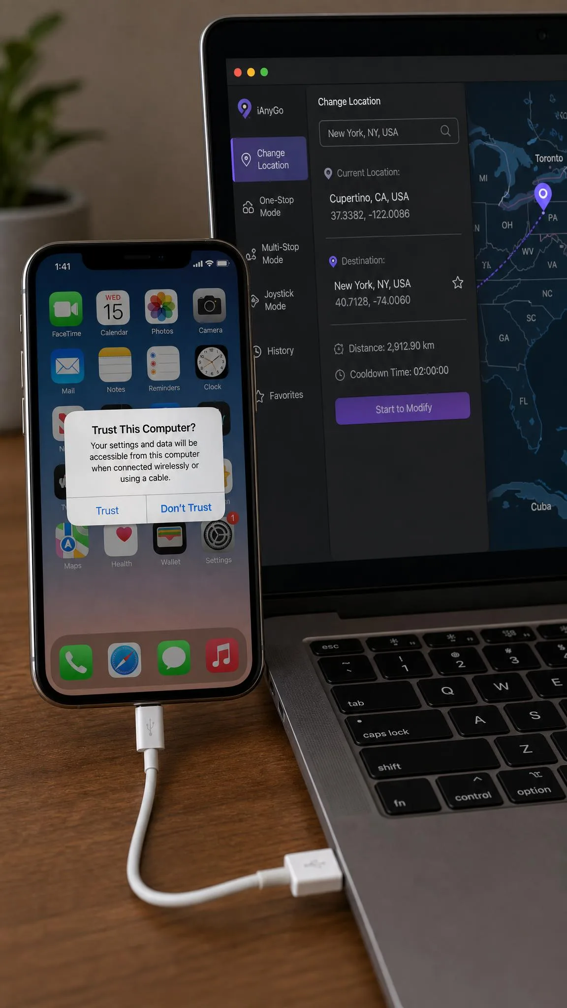An iPhone displaying the Trust This Computer prompt while plugged in by USB cable to a laptop running a GPS location changer.