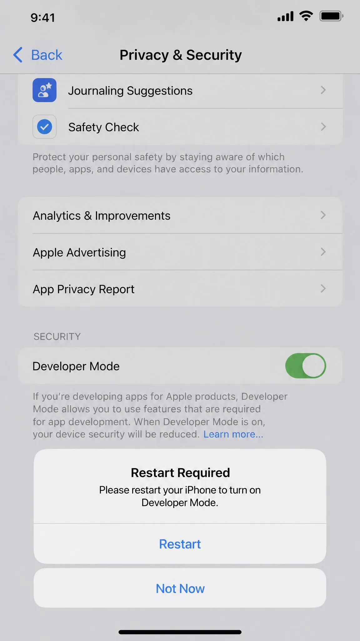 An iPhone Settings screen under Privacy and Security with the Developer Mode toggle switched on and the restart prompt showing.