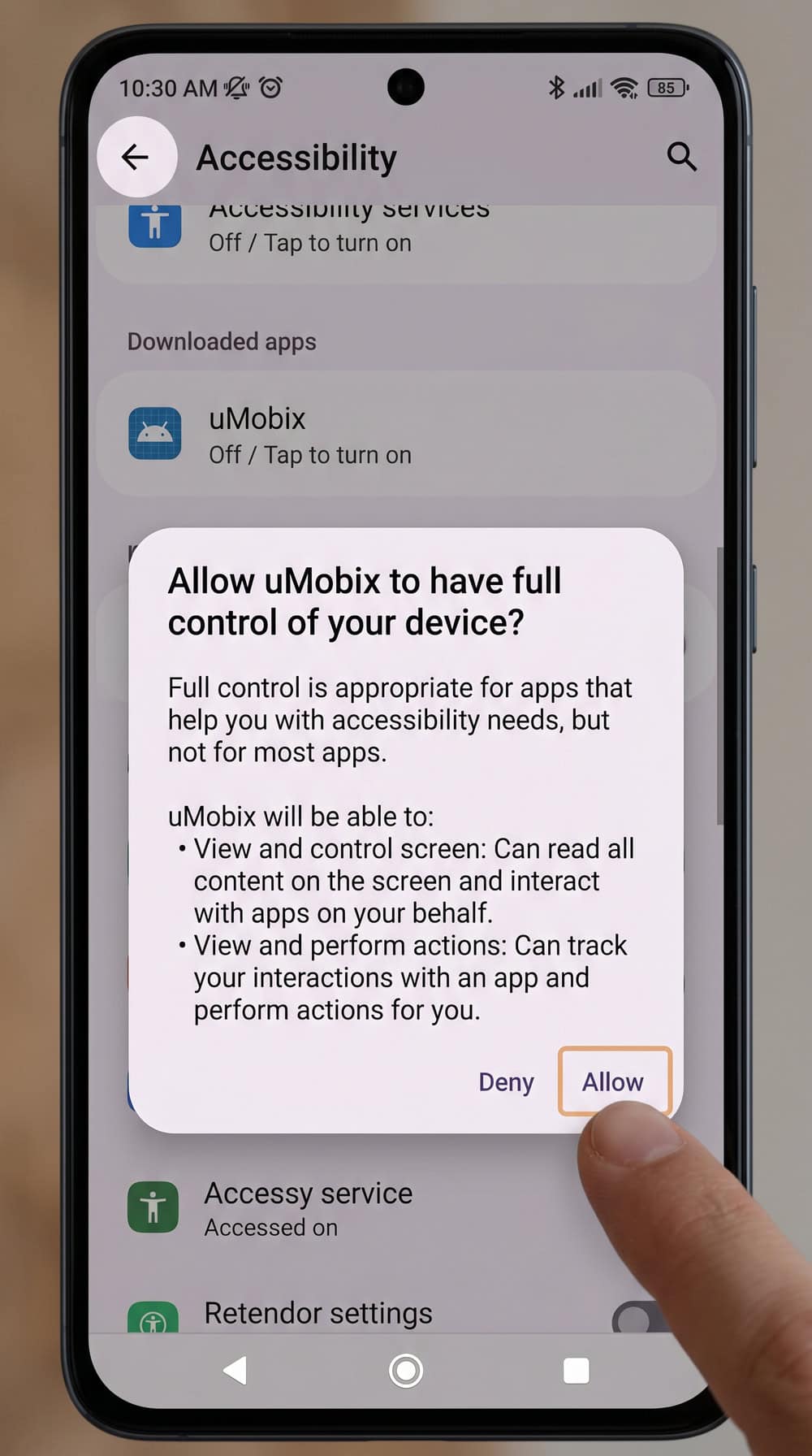 Android settings screen during uMobix setup showing the accessibility permission toggle being enabled for the monitoring app.